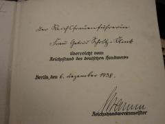 G45 / 2967 (Schramm, Ferdinand;Scholz-Klink, Getrud), Von Hand: Berufsangabe/Titel/Branche, Name, Datum, Widmung; 'der Reichsfrauenführerin Frau Getrud Scholtz-Klink [überreicht vom Reichstand des deutschen Handwerks Berlin, den] 6. Dezember 1938. Schramm [Reichshandwerksmeister]'. 